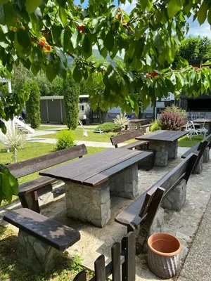 a picnic table and benches in a park at Hotel Neron Bihać in Lohovo