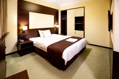 a hotel room with a large bed and a television at Boutique Hotel Golden Star in Tuzla