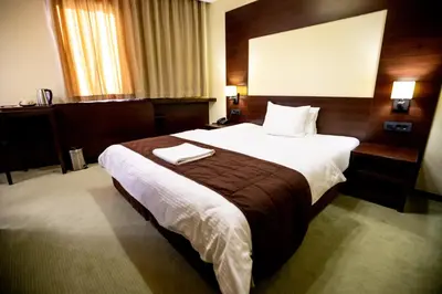 a bedroom with a large bed in a hotel room at Boutique Hotel Golden Star in Tuzla