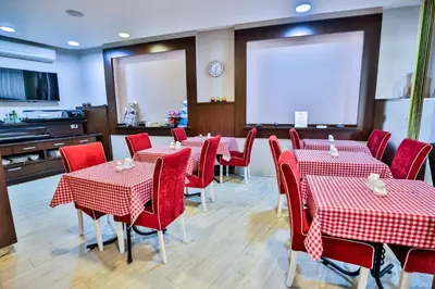 a dining room with red tables and red chairs at Boutique Hotel Golden Star in Tuzla