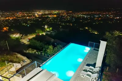 a swimming pool at night with a view of a city at Villa Wineyard - VinoGrad in Banja Luka