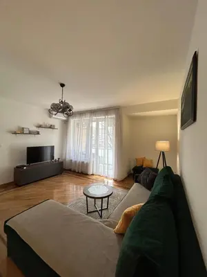 a living room with a green couch and a table at Vert Apartment in Banja Luka