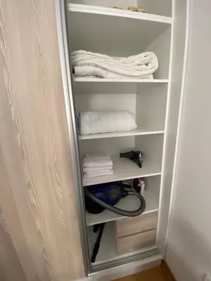 a closet with white shelves and towels at Vert Apartment in Banja Luka