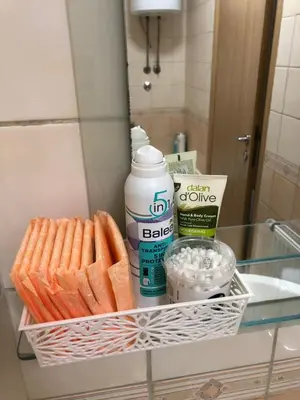 a basket of towels and other items on a shelf in a bathroom at Vert Apartment in Banja Luka