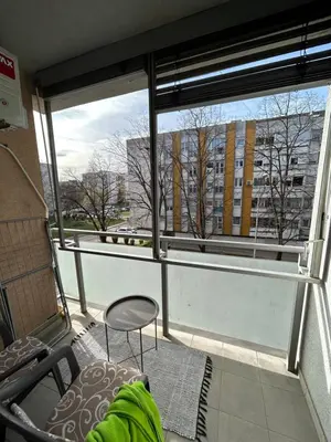 a balcony with a chair and a view of a building at Vert Apartment in Banja Luka