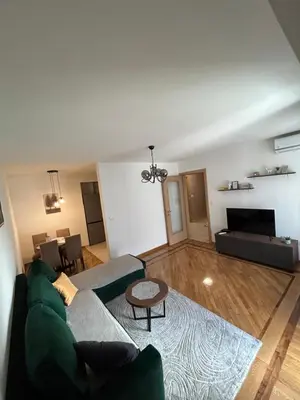 a living room with a green couch and a table at Vert Apartment in Banja Luka