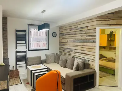 a living room with a couch and a wooden wall at Apartman SkiBeg, Vlašić in Vlasic