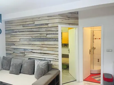 a living room with a wooden accent wall at Apartman SkiBeg, Vlašić in Vlasic