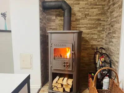 a wood fired oven in a kitchen with a brick wall at Apartman SkiBeg, Vlašić in Vlasic
