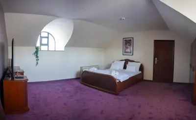 a bedroom with a bed and a purple carpet at Hotel Laktaši in Laktaši