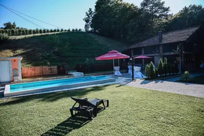 a yard with a chair and an umbrella next to a pool at Villa FORESTA in Banja Luka