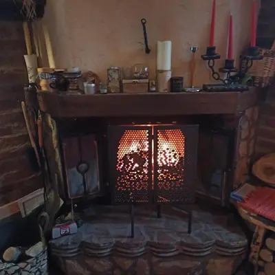 a fireplace in a room with two red candles at Villa FORESTA in Banja Luka
