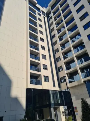 a tall white building with a car parked in front of it at GRAND LUX APARTMENTS in Banja Luka