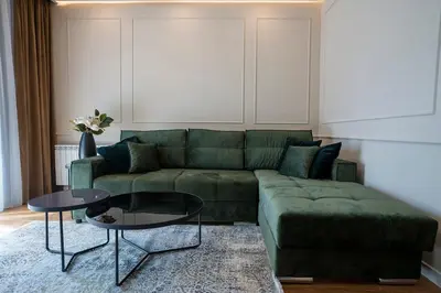 a living room with a green couch and a table at GRAND LUX APARTMENTS in Banja Luka