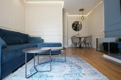a living room with a blue couch and a table at GRAND LUX APARTMENTS in Banja Luka