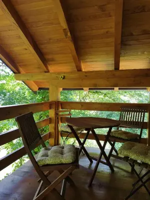 two chairs and a wooden table on a porch at Kuća u šumi - Forest house near National park Una - Air Spa Lohovo in Bihać