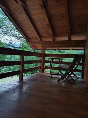 a wooden porch with a bench and a table at Kuća u šumi - Forest house near National park Una - Air Spa Lohovo in Bihać