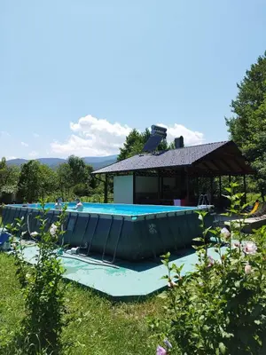 a large inflatable boat sitting next to a house at Kuća u šumi - Forest house near National park Una - Air Spa Lohovo in Bihać