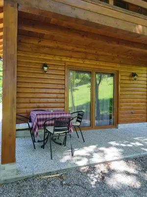 a table and chairs sitting outside of a house at Kuća u šumi - Forest house near National park Una - Air Spa Lohovo in Bihać