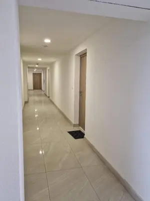 an empty hallway with white walls and a tile floor at Square Studio Tuzla in Tuzla