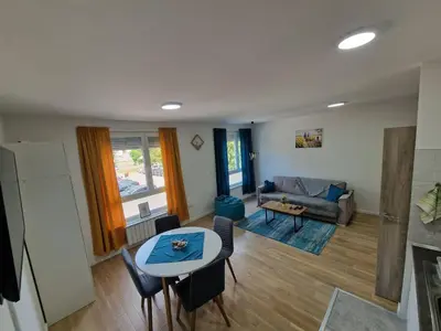 a living room with a table and a couch at Square Studio Tuzla in Tuzla