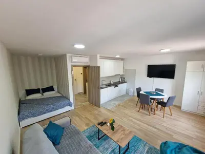 a bedroom and living room with a bed and a table at Square Studio Tuzla in Tuzla