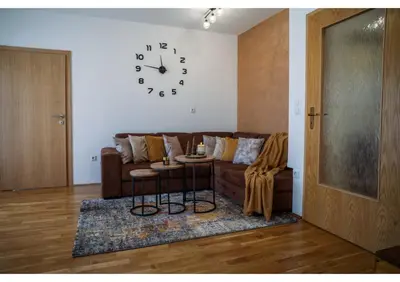 a living room with a couch and a clock on the wall at Holiday home Maša - Kupres in Kupres