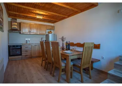 a kitchen with a wooden table and chairs in a room at Holiday home Maša - Kupres in Kupres