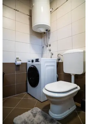 a bathroom with a toilet and a washing machine at Holiday home Maša - Kupres in Kupres