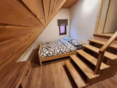a small room with a bed and a staircase at Holiday home Maša - Kupres in Kupres