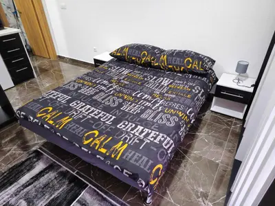 a bed with a black comforter and two pillows at MALM Travnik in Travnik