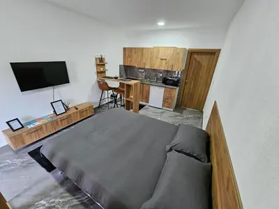 a bedroom with a bed and a desk and a kitchen at MALM Travnik in Travnik