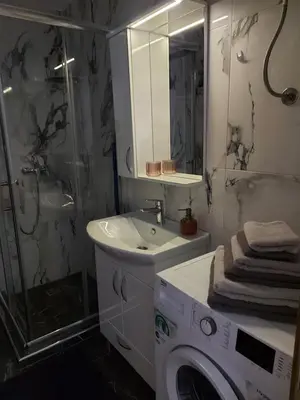 a bathroom with a washing machine and a sink at MALM Travnik in Travnik