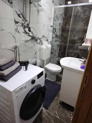 a bathroom with a toilet and a washing machine at MALM Travnik in Travnik