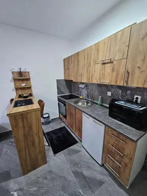 a kitchen with wooden cabinets and a sink at MALM Travnik in Travnik