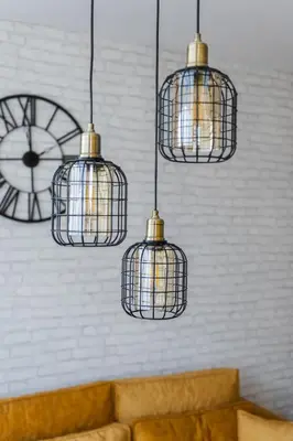 four bird cages hanging from a wall with a clock at Comfort Lux Residence in Banja Luka