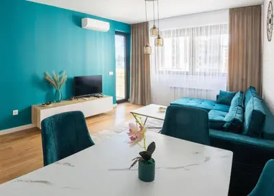 a living room with a white table and blue walls at Comfort Lux Residence in Banja Luka