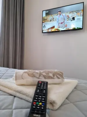 a remote control sitting on top of a bed with a television at Comfort Lux Residence in Banja Luka