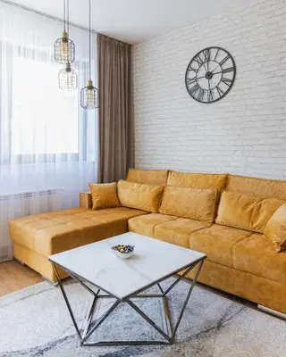 a living room with a couch and a clock on the wall at Comfort Lux Residence in Banja Luka