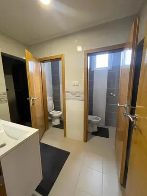 a bathroom with two toilets and a sink at Apartmani BROD in Zenica