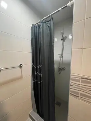 a shower with a black shower curtain in a bathroom at Apartmani BROD in Zenica