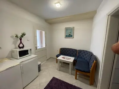 a small room with a couch and a microwave at Apartmani BROD in Zenica