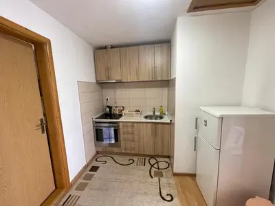a small kitchen with a sink and a refrigerator at Apartmani BROD in Zenica