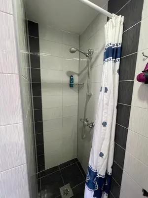 a shower with a shower curtain in a bathroom at Apartmani BROD in Zenica