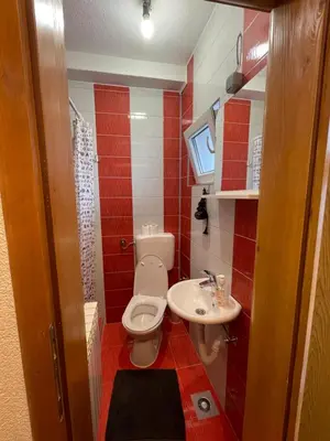 a small bathroom with a toilet and a sink at Apartmani BROD in Zenica