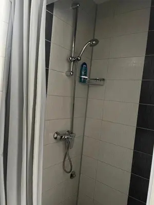 a shower in a bathroom with a shower curtain at Apartmani BROD in Zenica