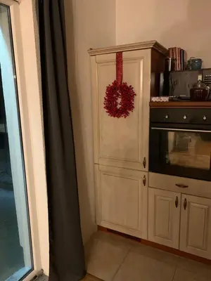 a kitchen with a microwave and a cabinet with a wreath at Rosa Canina Kupres in Kupres