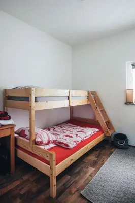 a wooden bunk bed in a room with a desk at Rosa Canina Kupres in Kupres