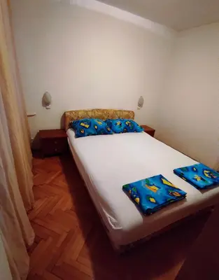 a bedroom with a bed with blue pillows on it at Heart of the City in Banja Luka