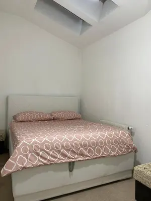 a bedroom with a pink bed in a room at Unas apartment in Bihać
